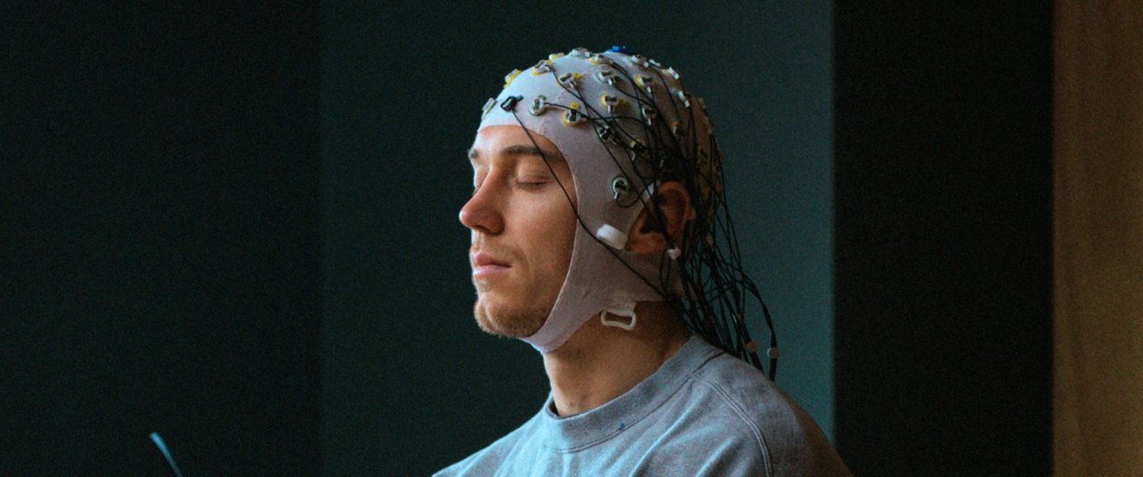 A man is wearing a futuristic electronic device on his head