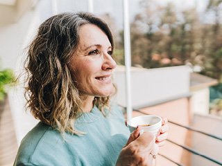 Lady looking out while drinking tea