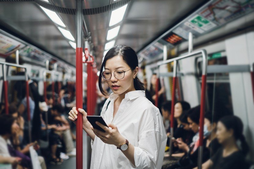 Woman looking at her smartphone while on a train