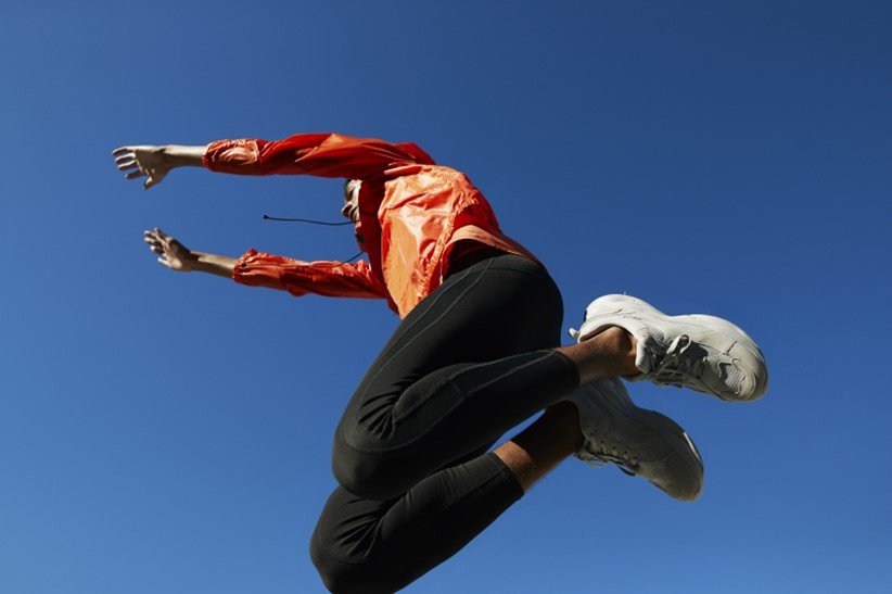 Young man jumping against clear blue sky