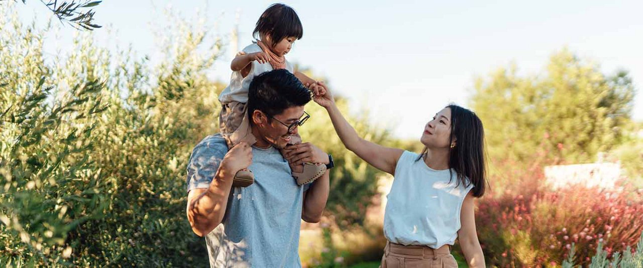 Parents outdoors with child on dads shoulders