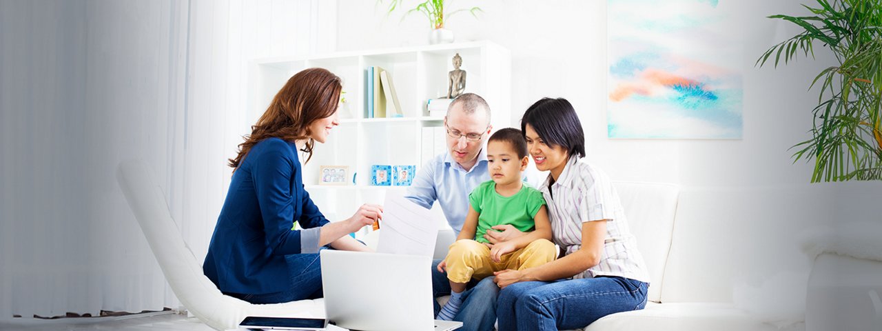 Sitting together at a laptop screen is a family of three with a tax accountant