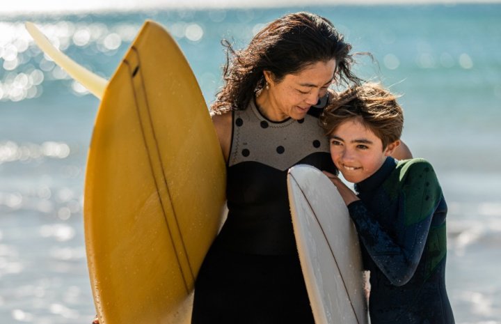 Mother and son at the beach with surfboards