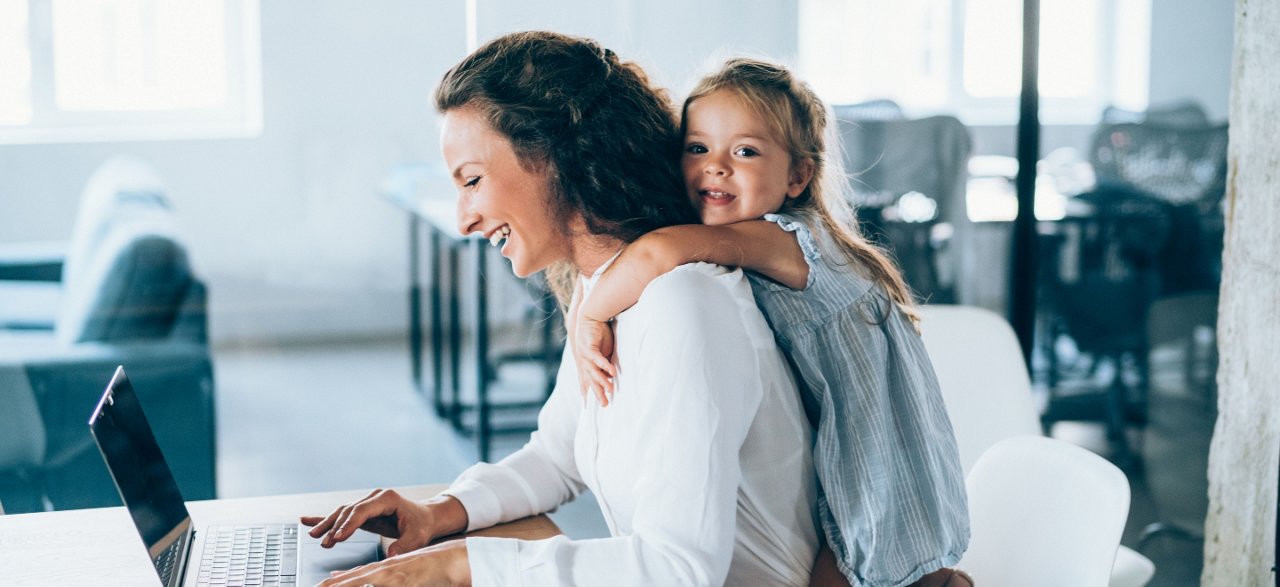 mother at laptop and toddler daughter 