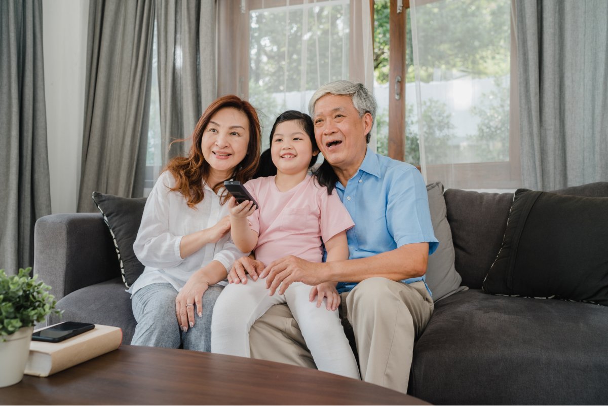 一名老人家和女兒及孫女正在開心地看電視