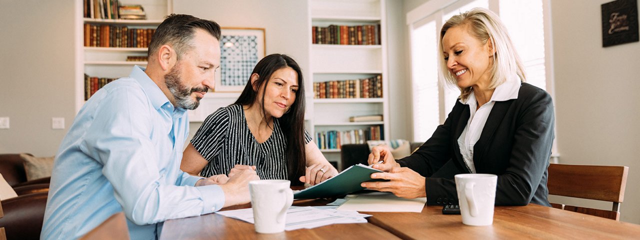 Three individuals enjoying coffee at a table.