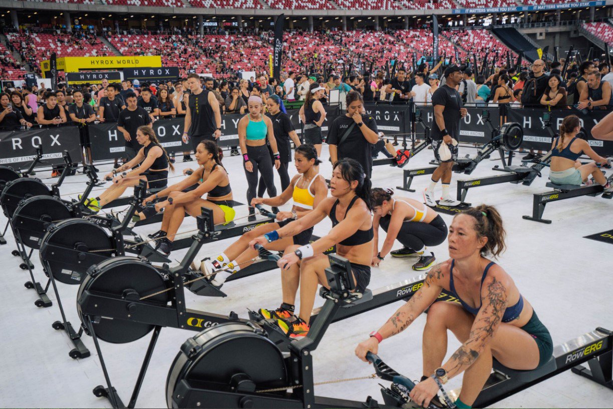 Participants on rowing machines during HYROX