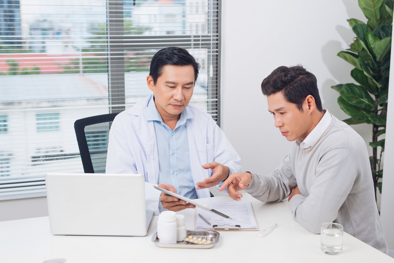 Asian man in doctor's office getting a diagnosis