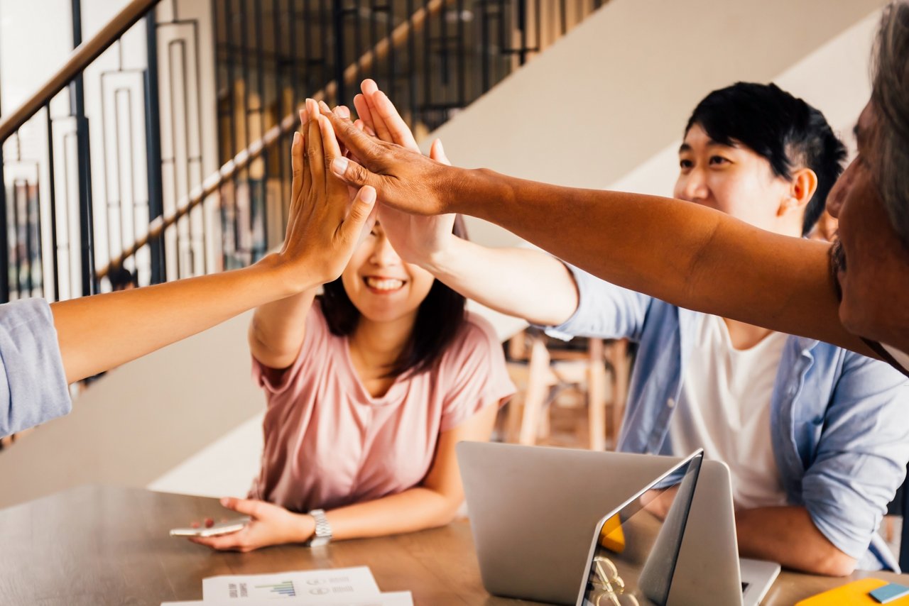 Young Asians put their hands together in unity.