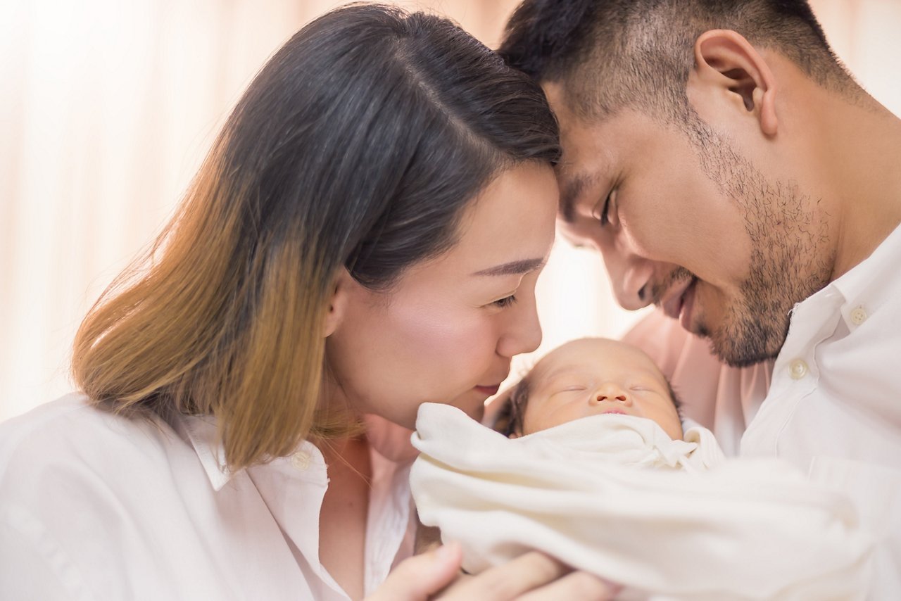 A couple holds their newborn.