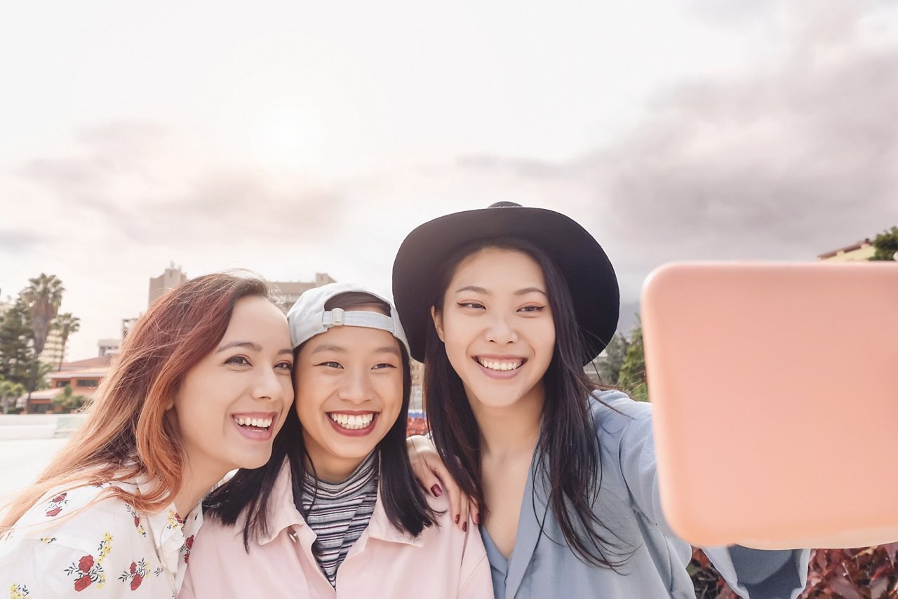 Three female friends take a group photo.