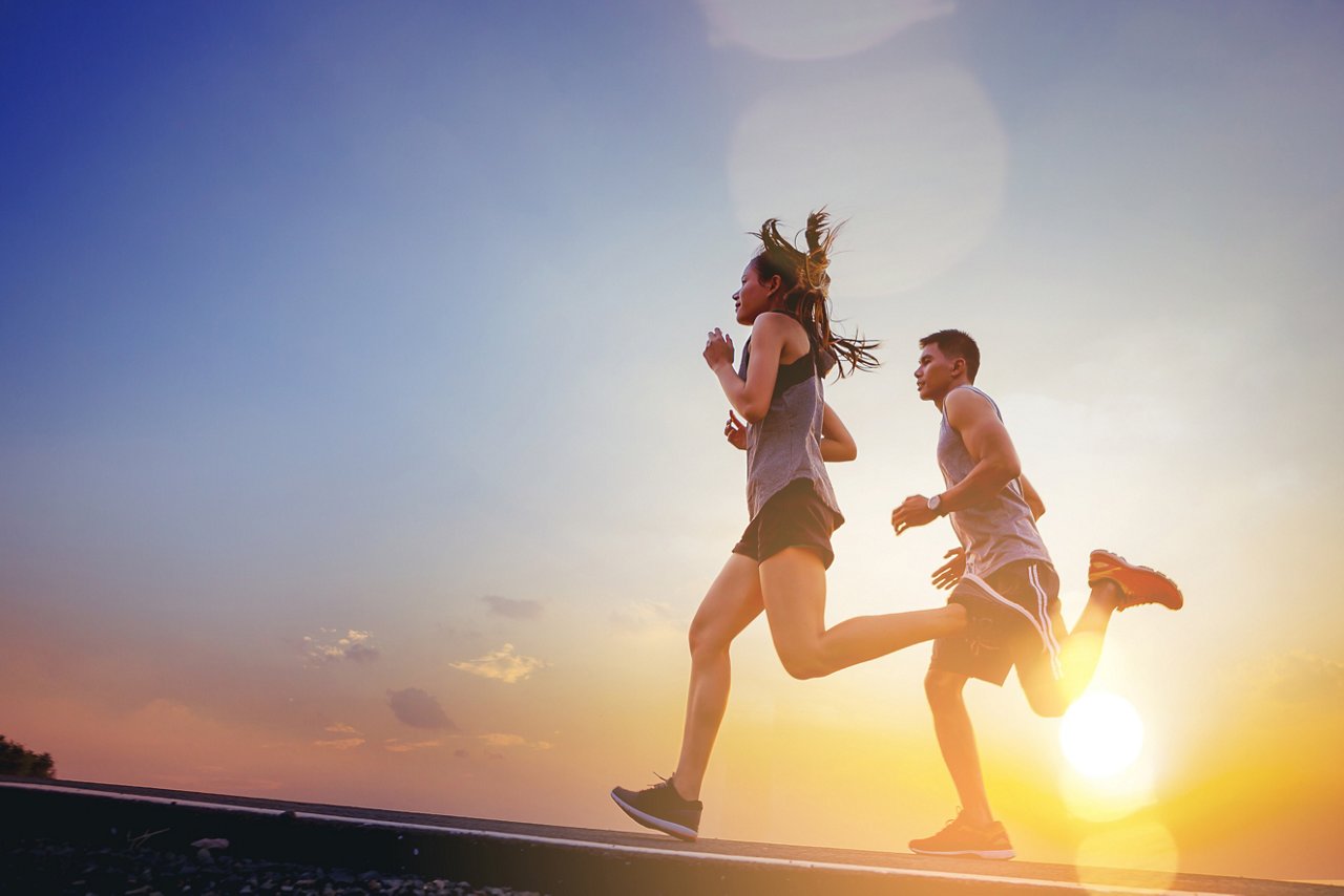 一對亞裔夫婦在黃昏時跑步，這是一項有益心臟健康的運動。