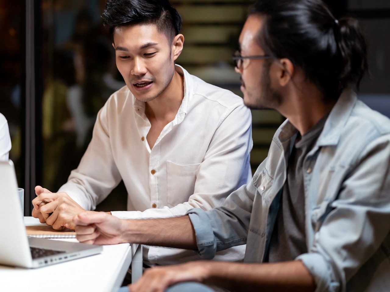 Two young Asian businessmen work and brainstorm together