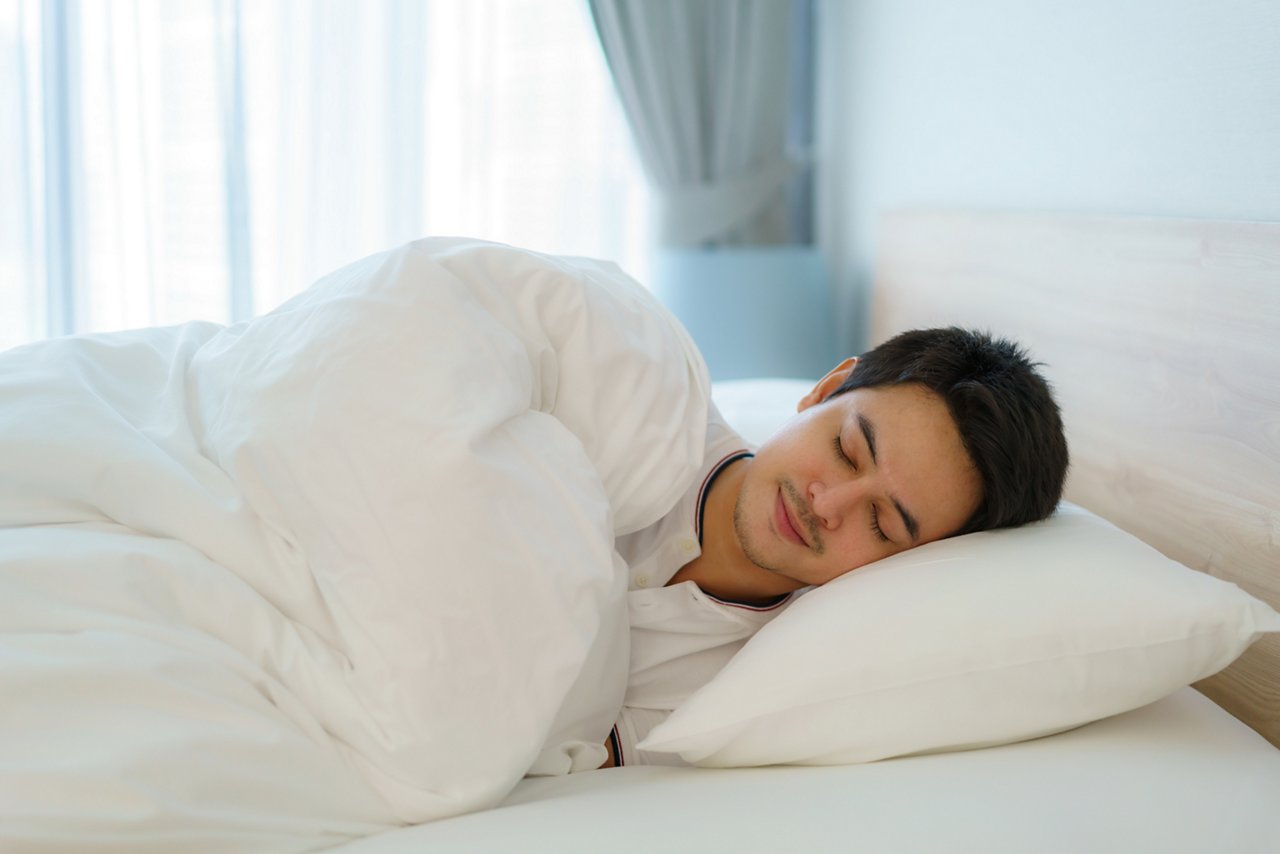 A man asleep on the bed.