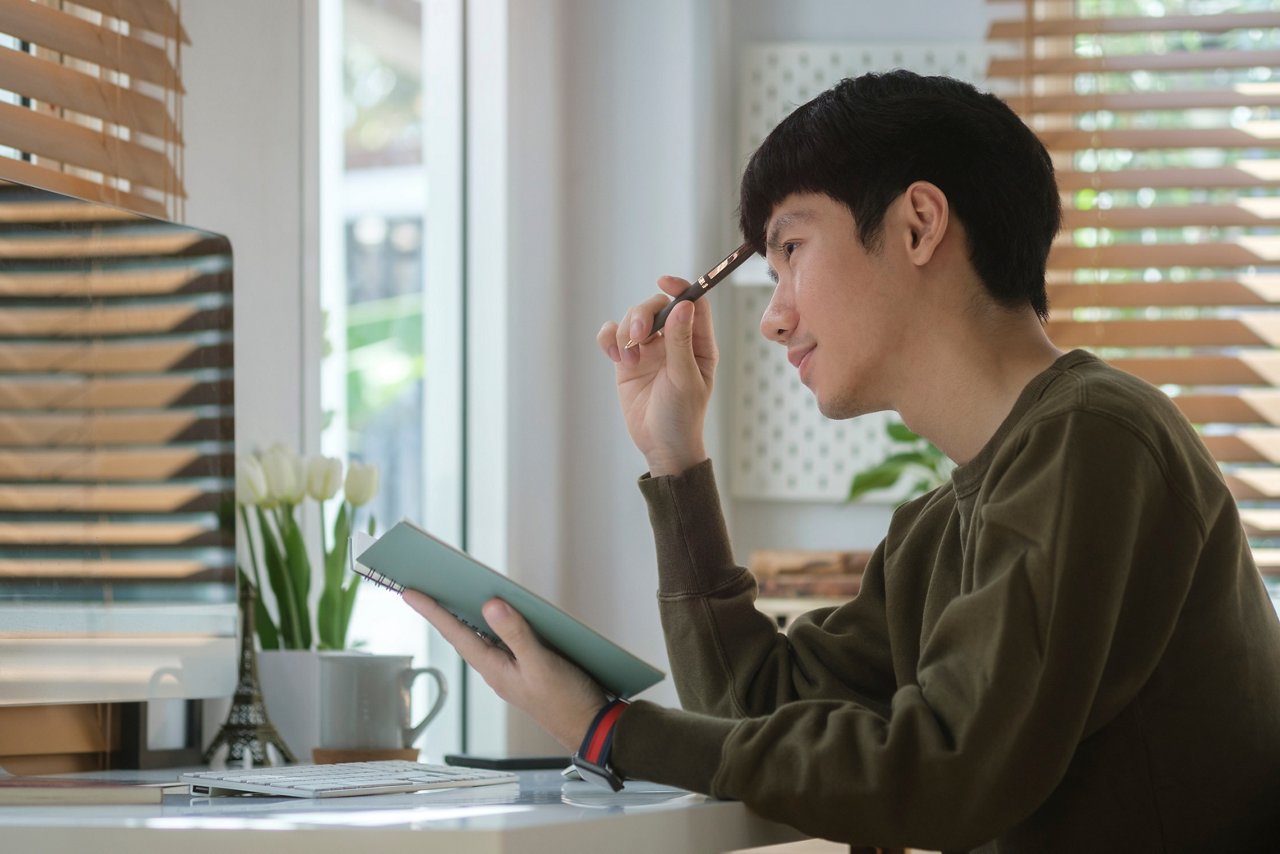 A man pondering while looking at his computer screen