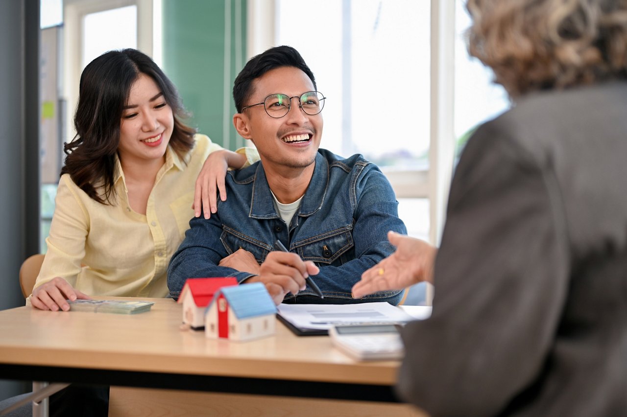 Young Asian couple meets with a real estate agent.