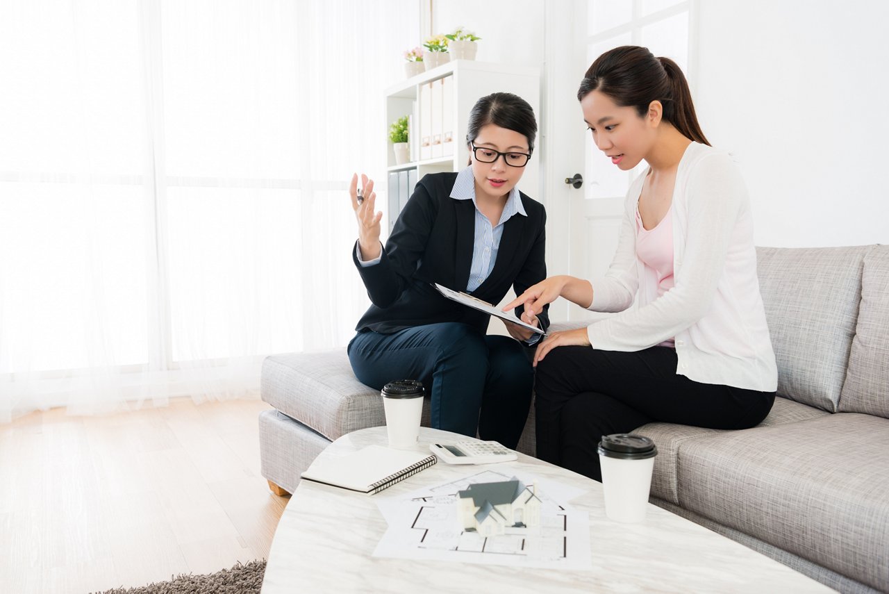A real estate agent explaining a document to a client before making a home purchase.
