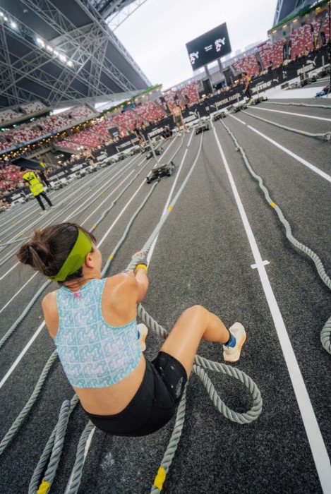 Woman pulling a weighted sled using a rope.