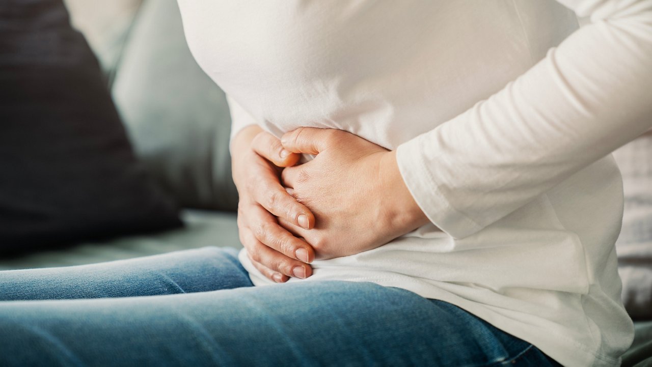 Older man speaking with a doctor about stomach cancer symptoms, abdominal pain, digestive issues, and early warning signs. 