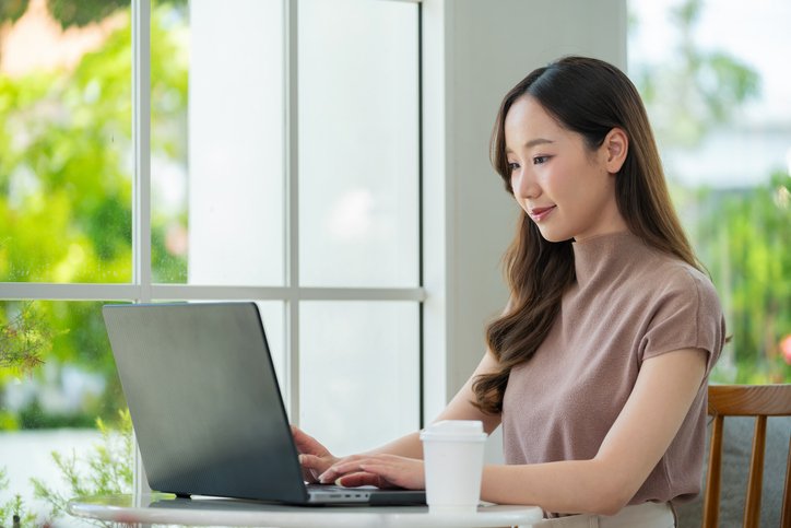 亞洲女性進行視像通話，與醫生進行網上問診，反映視像診症在網上睇醫生中的普及，並突顯門診保險是否涵蓋視像診症及送藥服務的重要性。