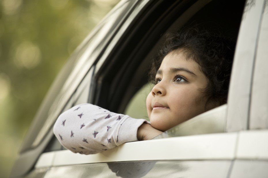 Smiling child looks out of car