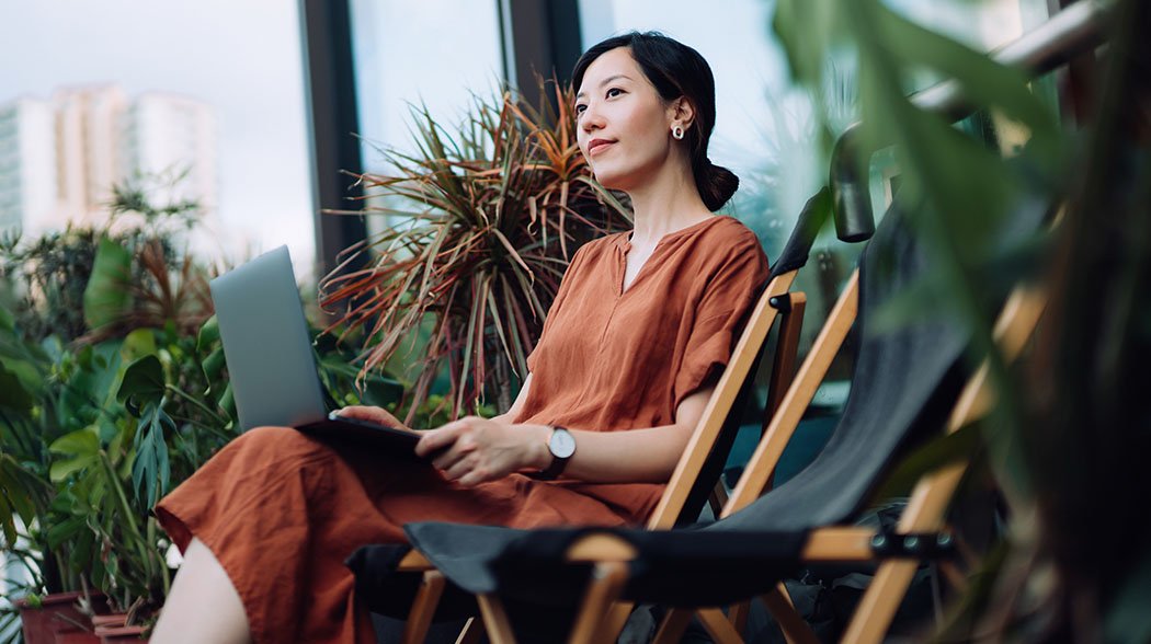 Woman working with laptop and admiring nature