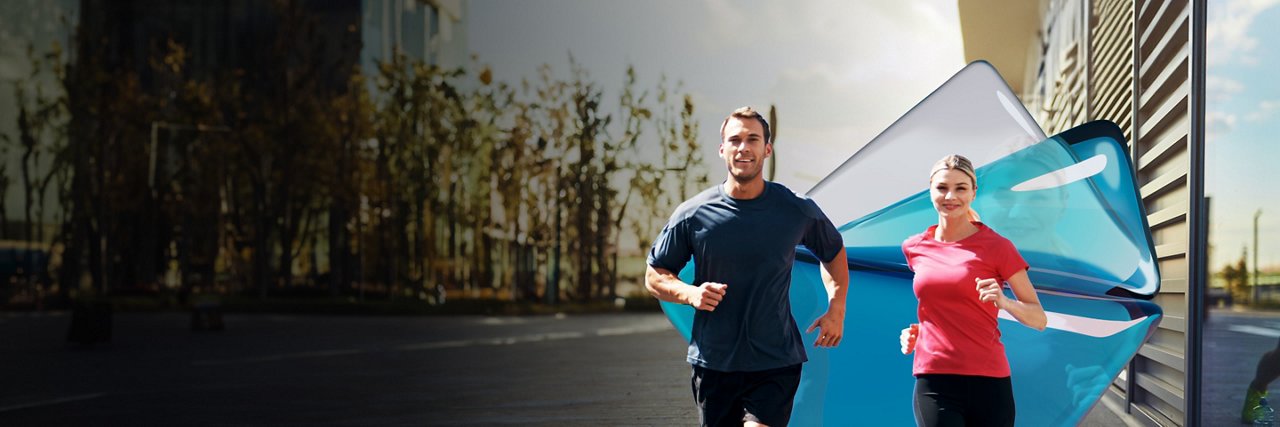 A man and woman jogging on a street in their gym gear.