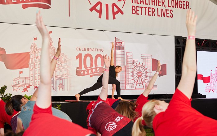 A group of people practicing yoga on stage.