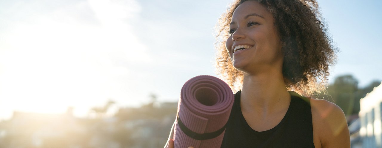 a woman holding a yoga mat