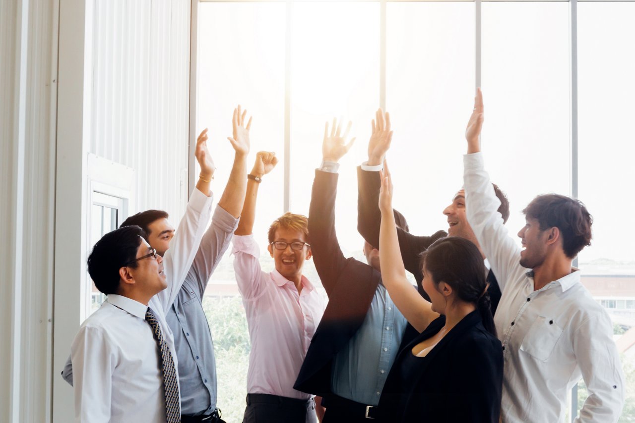 Office workers raise their hands to cheer