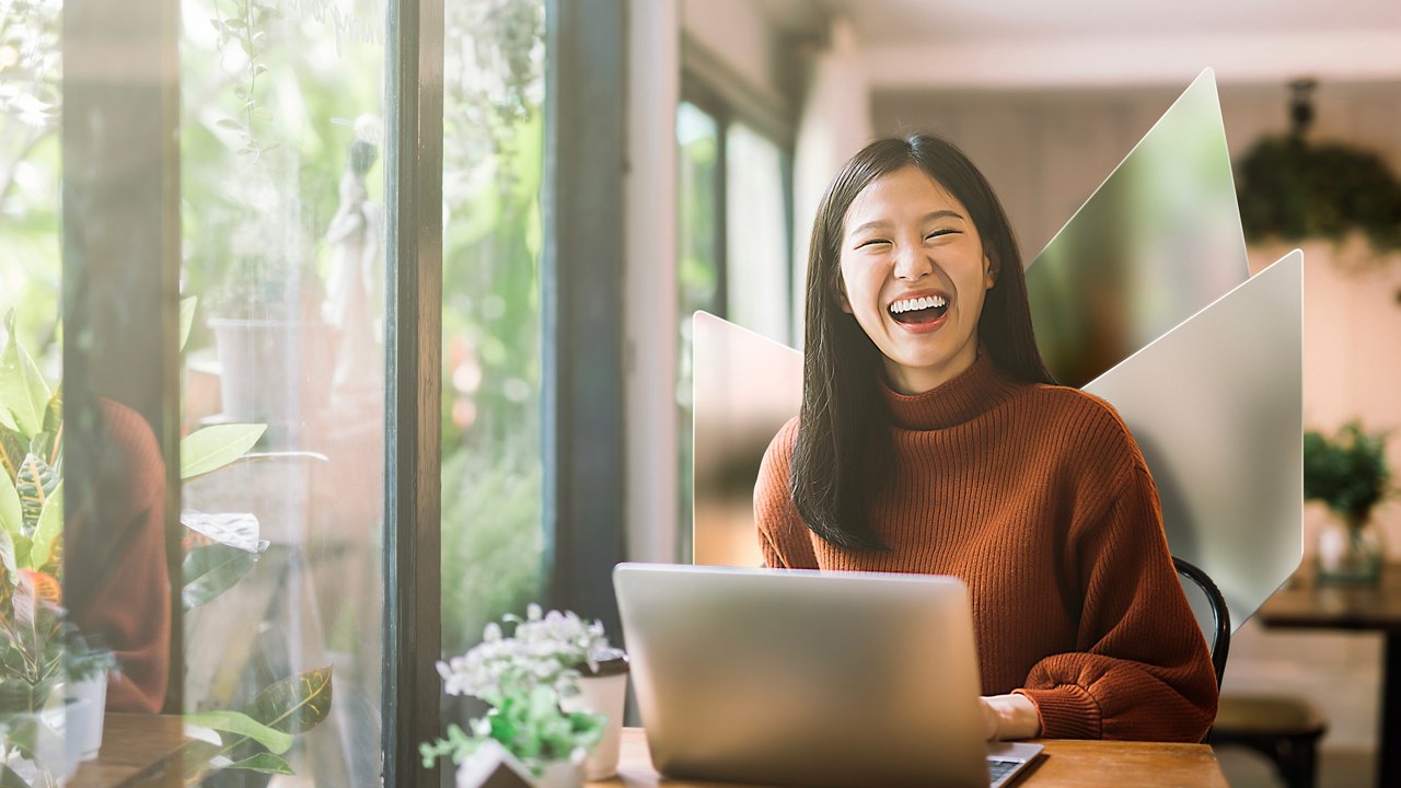 Lovely Asian girl and mother celebrating birthday with friends / family by having a virtual birthday party at home. Enjoying birthday celebration in front of the laptop during pandemic. Practicing social distancing. Birthday lifestyle theme
