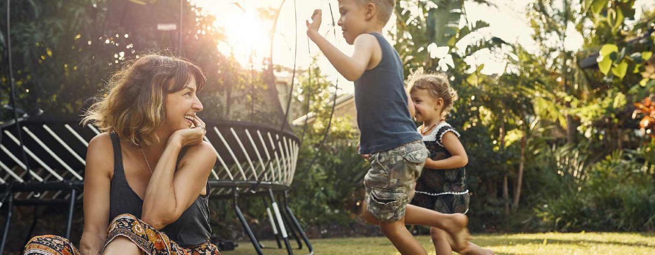 lady watching kids jumping near trampoline