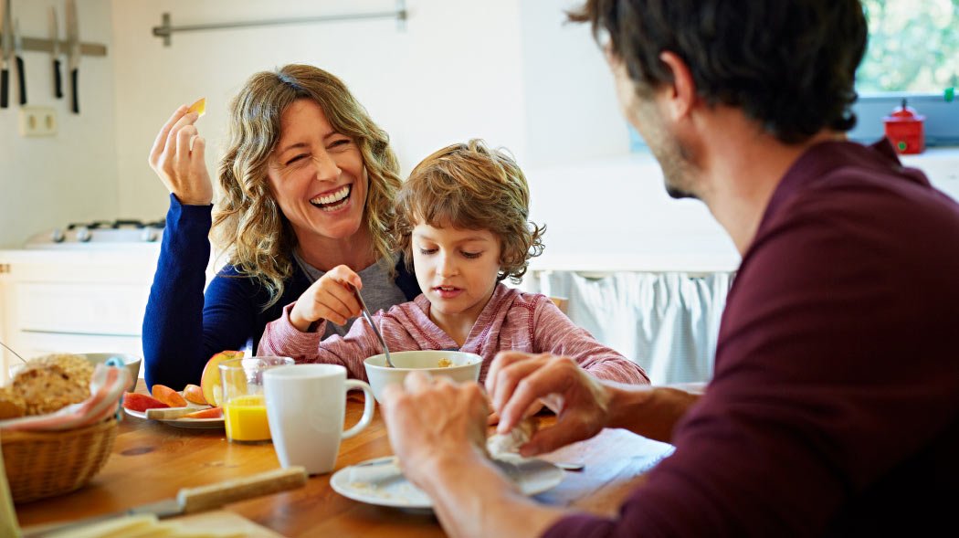 a family is sitting on a dining table