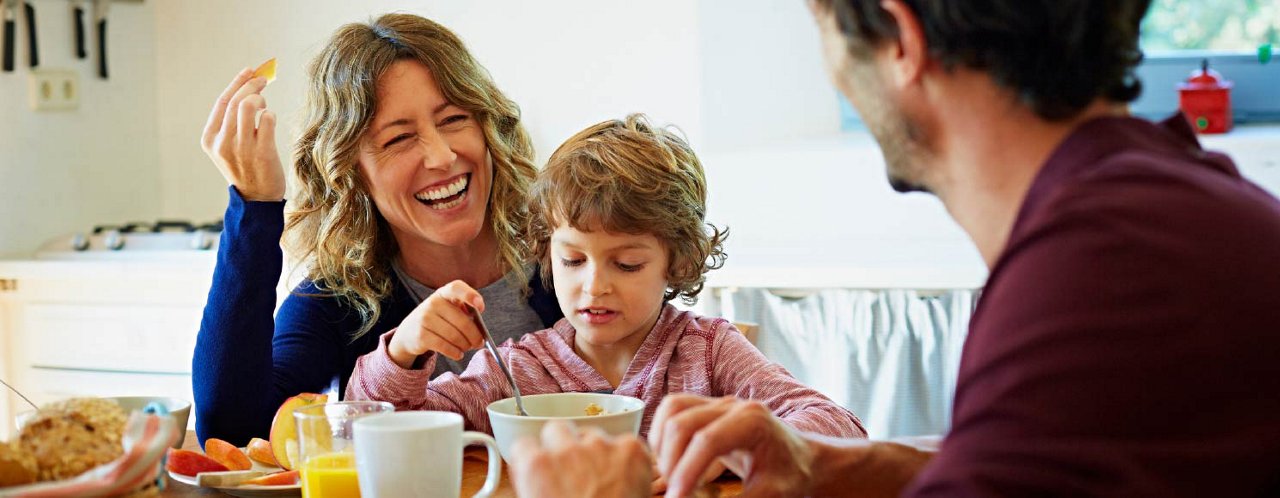 Couple with kid chatting in dinning table