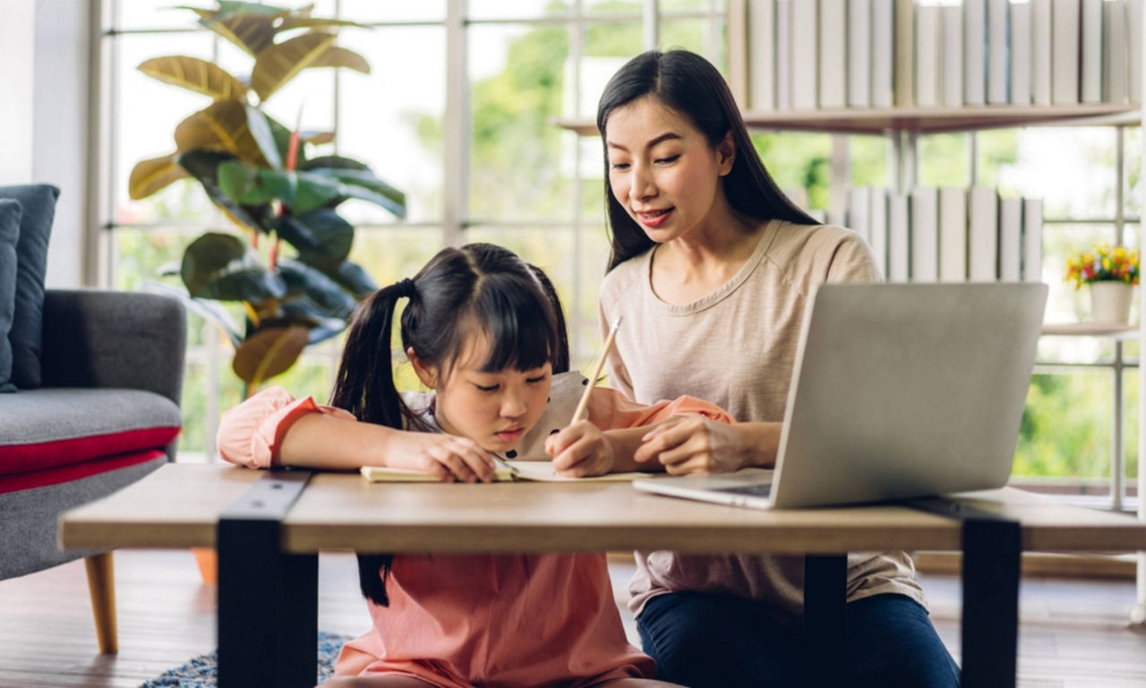 Asian mother helps her child with her homework 