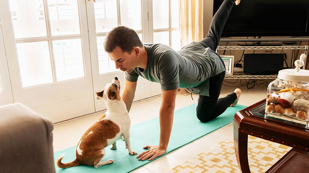 man doing yoga with dog