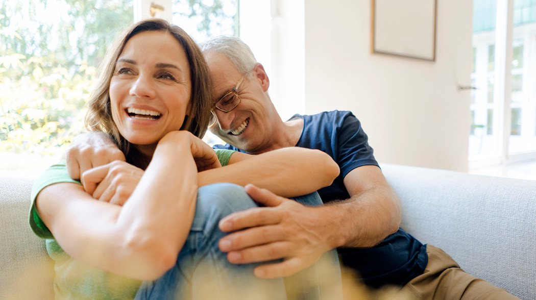 a man sitting on a couch holding a woman