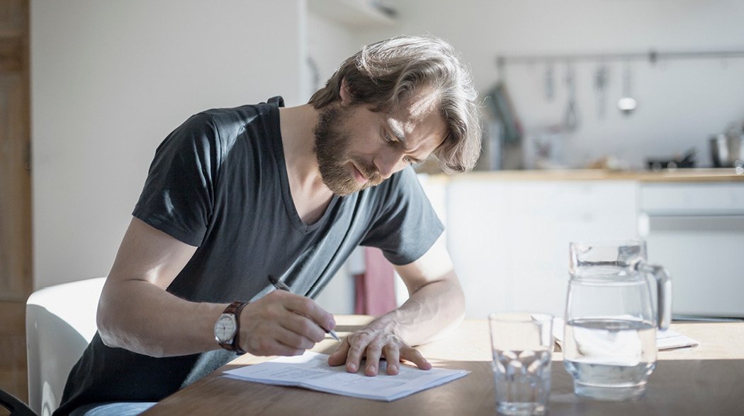 a man sitting on a table and writing
