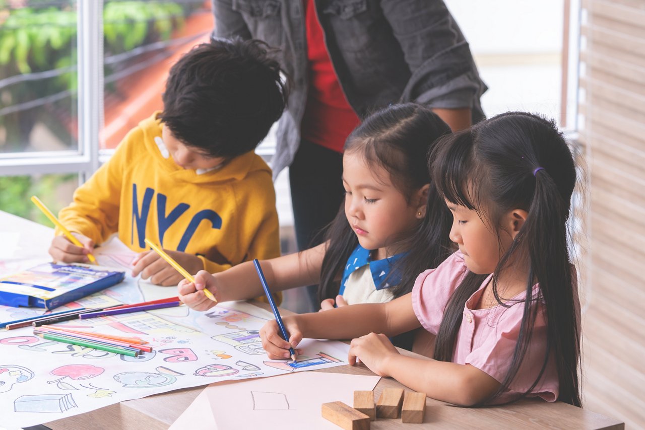 Preschool students draw and colour together