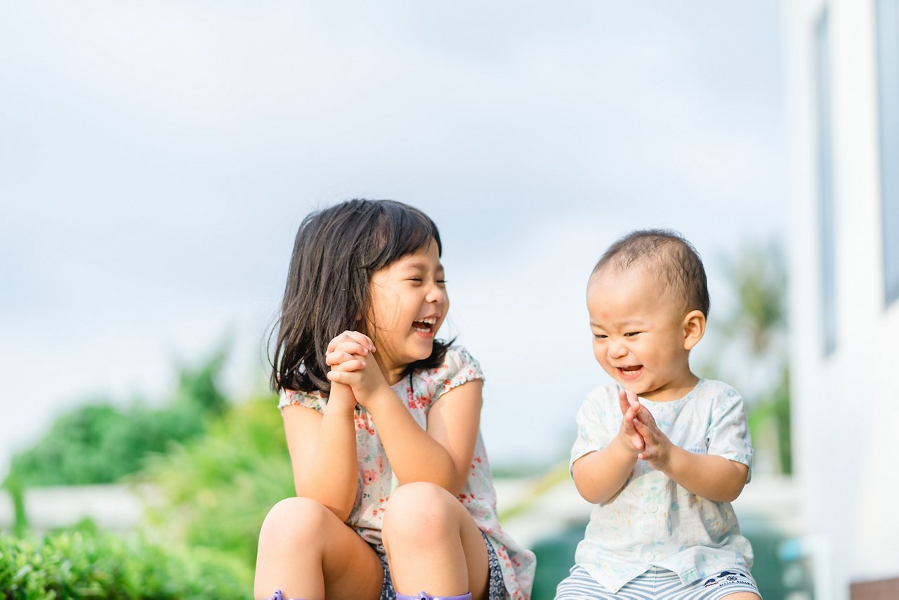 Little girl plays with her toddler brother