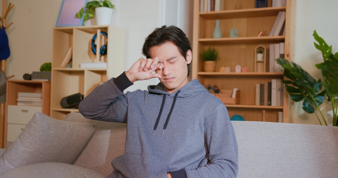 A young man rubbing his eyes