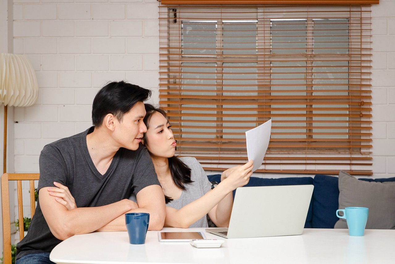 Young couple looks at a spreadsheet as they discuss financial plans 
