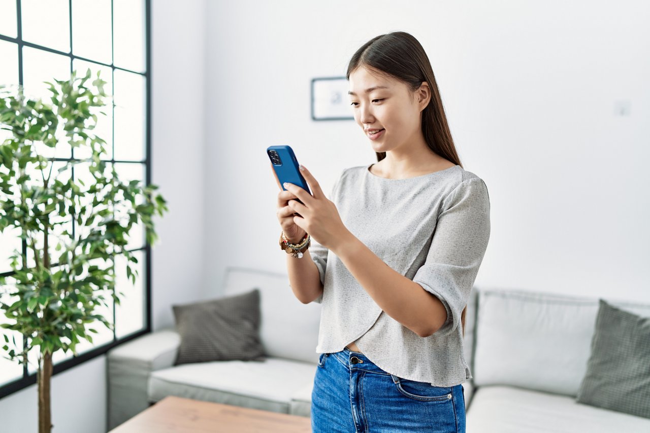 A woman using her phone while standing up