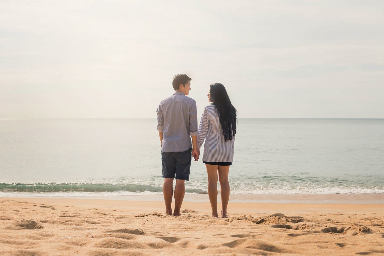 一對年輕夫婦站在沙灘上