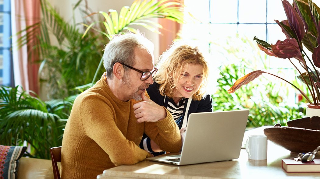 a man and a woman working on a laptop