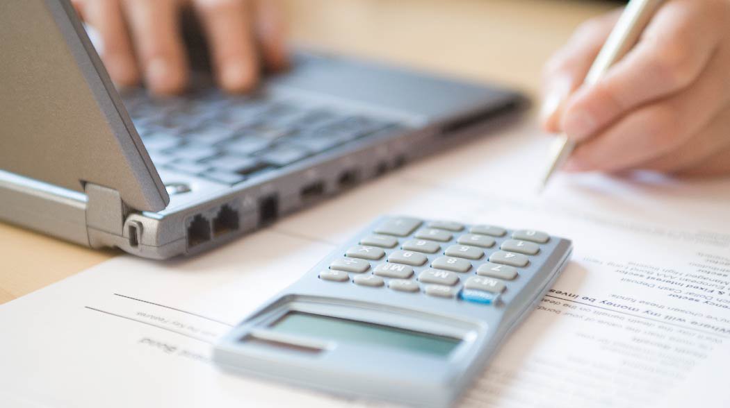 a laptop and a calculator kept on a table