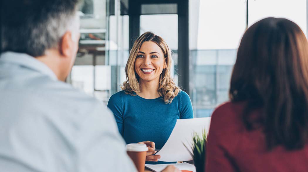 a woman speaking to a man and woman