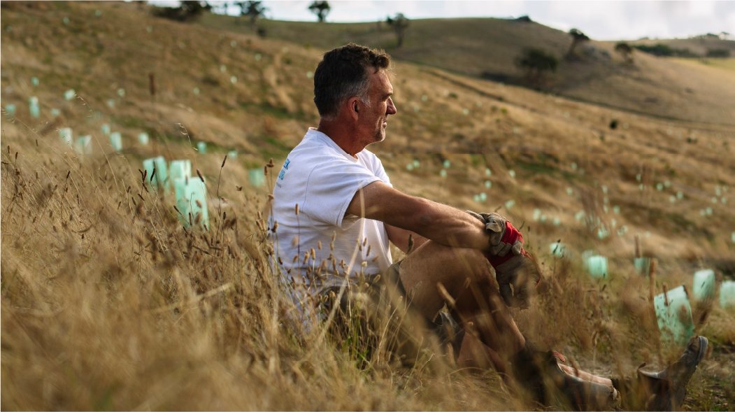 a man sitting on a grassland