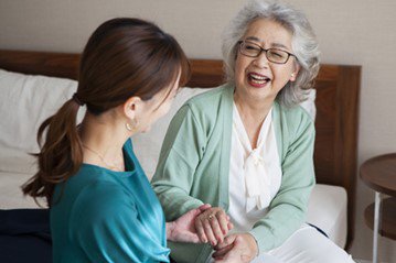 a girl holding hand of an old woman