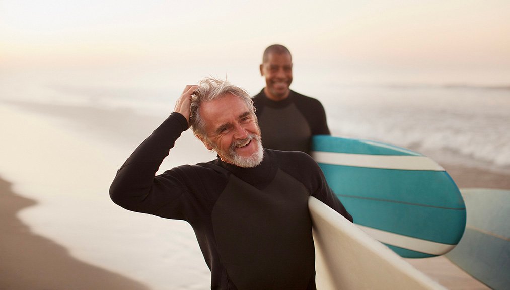 2 mens holding surfing boards